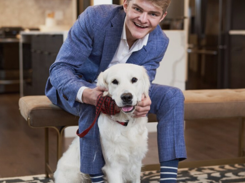 A man in blue suit and white dog