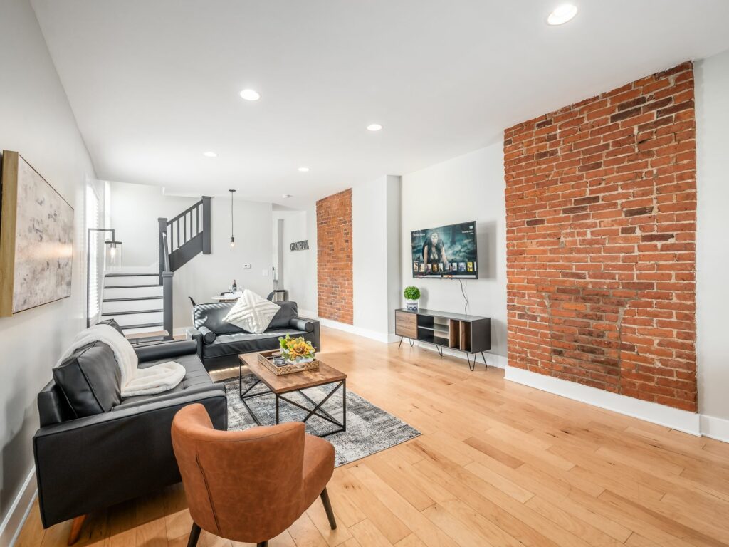 A living room with hard wood floors and brick walls.